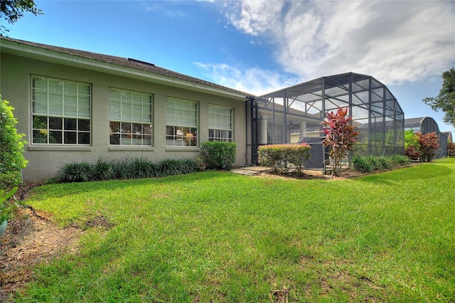 rear view of house with a lawn and a lanai