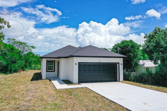 view of front of property featuring a front yard and a garage