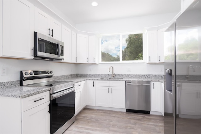 kitchen featuring white cabinets, light hardwood / wood-style flooring, stainless steel appliances, and sink