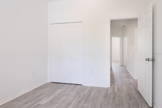 unfurnished bedroom with a closet and light hardwood / wood-style floors