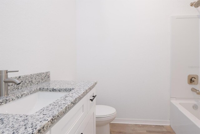 full bathroom with vanity, toilet, wood-type flooring, and shower / tub combination