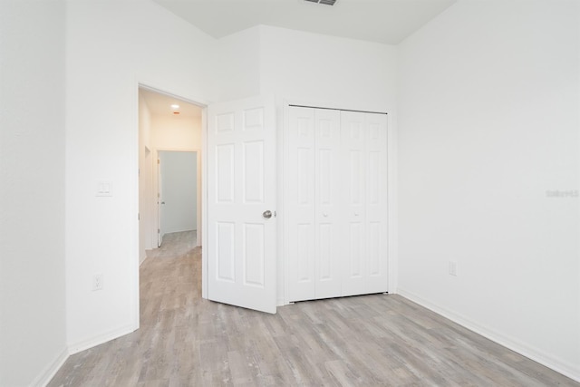 unfurnished bedroom featuring a closet and light hardwood / wood-style floors