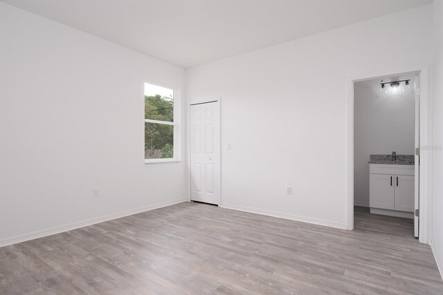 unfurnished bedroom featuring light hardwood / wood-style flooring and sink