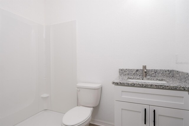 bathroom featuring vanity, toilet, and a shower