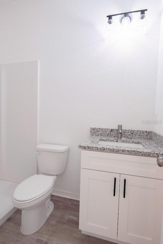 bathroom featuring hardwood / wood-style floors, toilet, and vanity