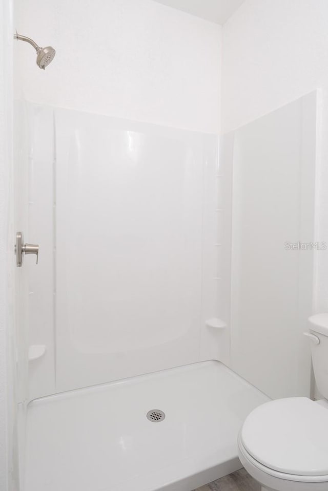 bathroom with toilet and walk in shower