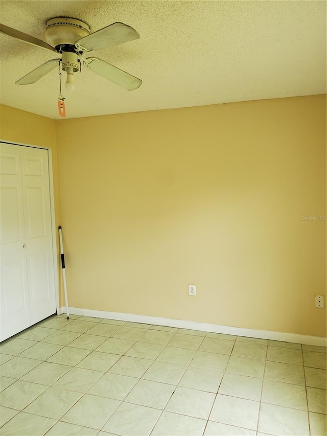 unfurnished room with light tile patterned flooring, a textured ceiling, and ceiling fan