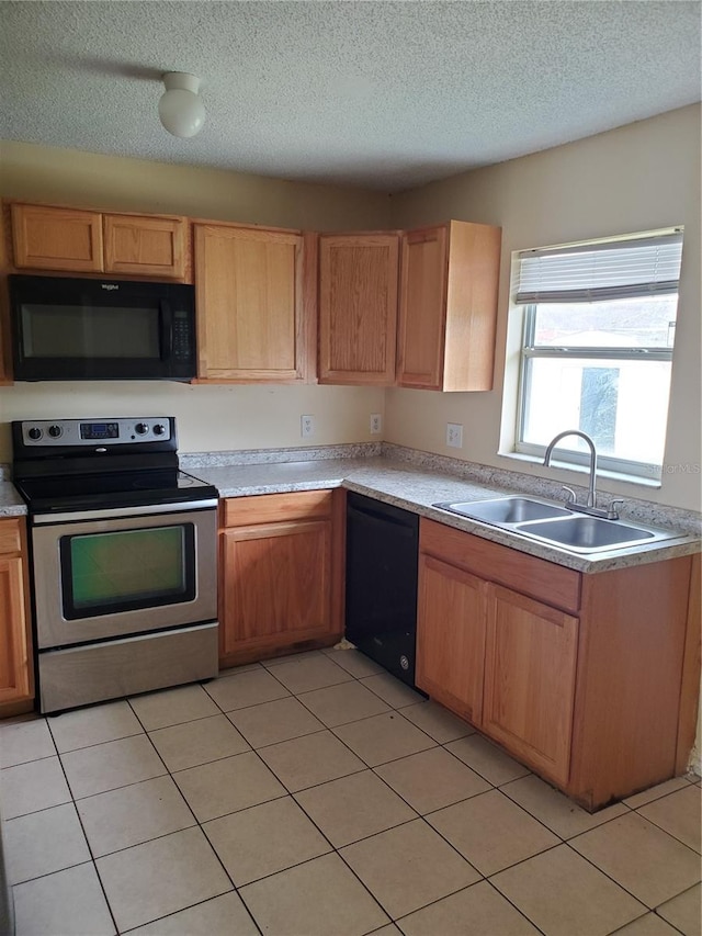 kitchen with black appliances, sink, light tile patterned floors, and a textured ceiling