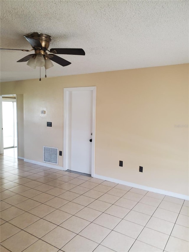 unfurnished room featuring ceiling fan, light tile patterned floors, and a textured ceiling