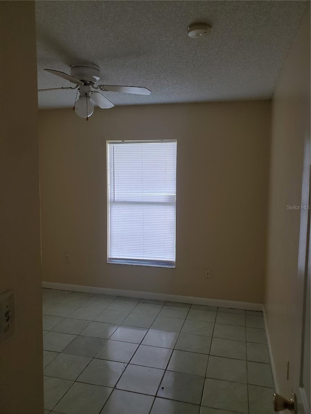 unfurnished room featuring ceiling fan, a textured ceiling, and light tile patterned floors