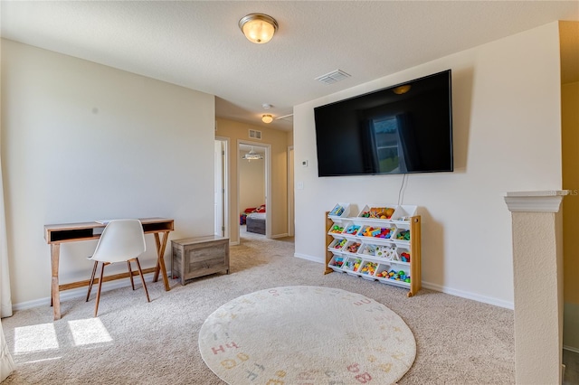 playroom featuring light carpet and a textured ceiling