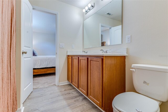 bathroom with vanity, toilet, and wood-type flooring