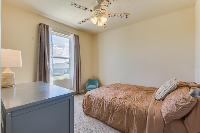 carpeted bedroom featuring a textured ceiling and ceiling fan