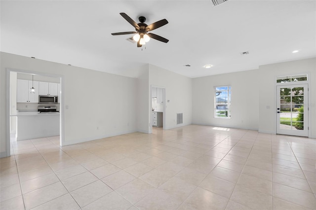 unfurnished living room with ceiling fan and light tile patterned flooring