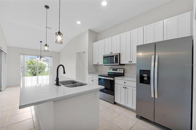 kitchen with appliances with stainless steel finishes, a kitchen island with sink, sink, white cabinetry, and lofted ceiling