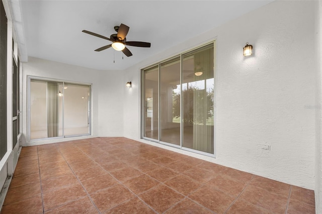 unfurnished sunroom featuring ceiling fan