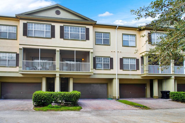 view of property with a balcony and a garage