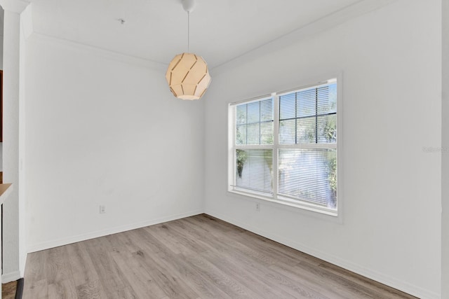 unfurnished dining area featuring ornamental molding and light hardwood / wood-style floors