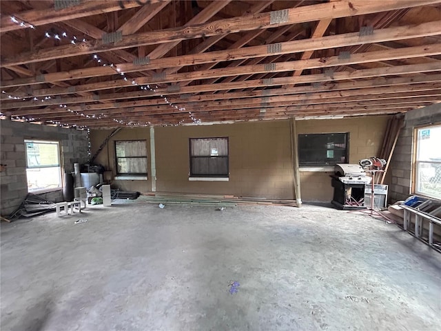 interior space with concrete block wall and unfinished concrete flooring