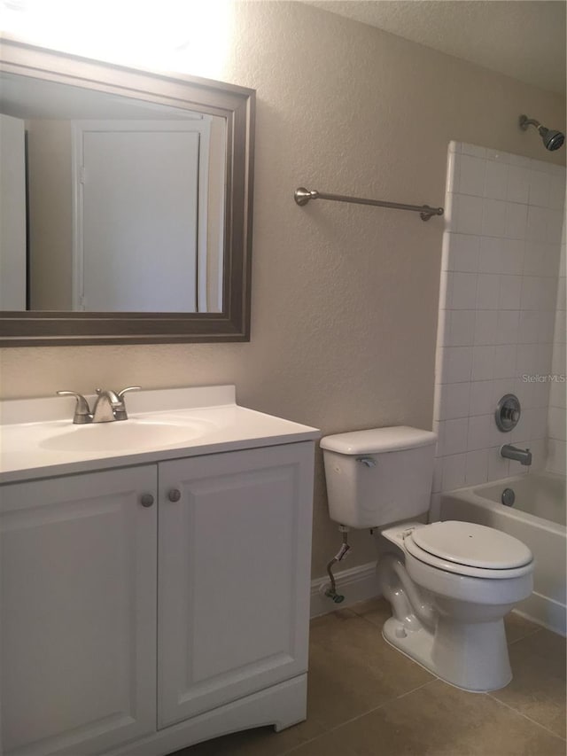 full bathroom featuring tiled shower / bath combo, vanity, toilet, and tile patterned flooring