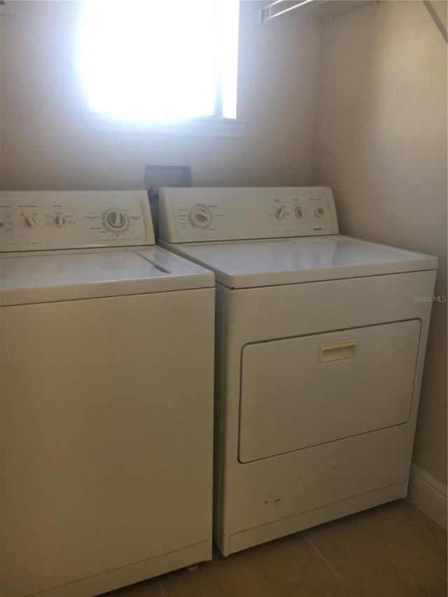 laundry room featuring separate washer and dryer and light tile patterned flooring