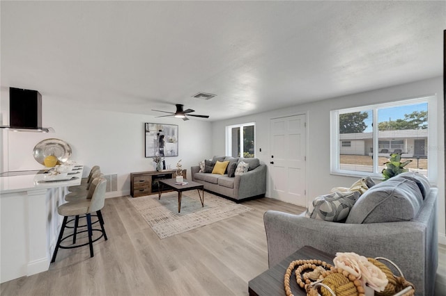 living room featuring light hardwood / wood-style flooring and ceiling fan