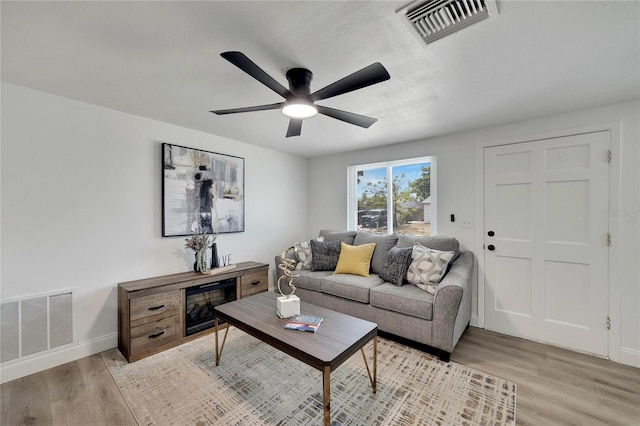 living room featuring light hardwood / wood-style flooring and ceiling fan