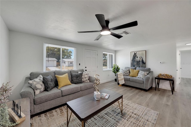 living room with light hardwood / wood-style flooring and ceiling fan