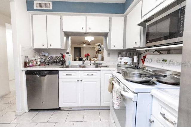 kitchen featuring backsplash, stainless steel appliances, and white cabinets