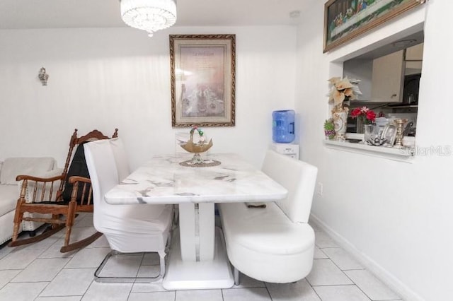 dining area with a chandelier and light tile patterned flooring