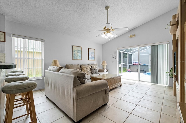 tiled living room with vaulted ceiling, a textured ceiling, and ceiling fan