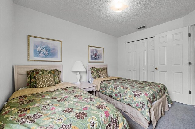 carpeted bedroom with a textured ceiling and a closet