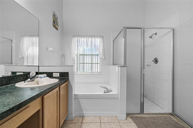 bathroom with tile patterned flooring, separate shower and tub, and vanity