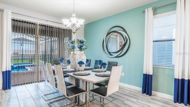 dining room with light wood-type flooring and an inviting chandelier