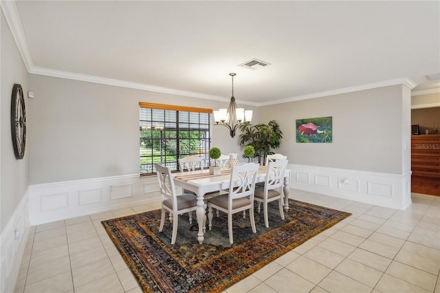 dining area with ornamental molding, a chandelier, and light tile patterned floors