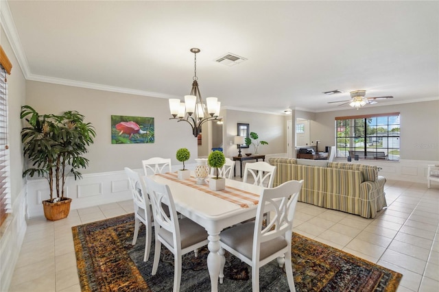 dining room with ceiling fan with notable chandelier, crown molding, and light tile patterned floors