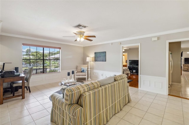 tiled living room with ceiling fan and ornamental molding