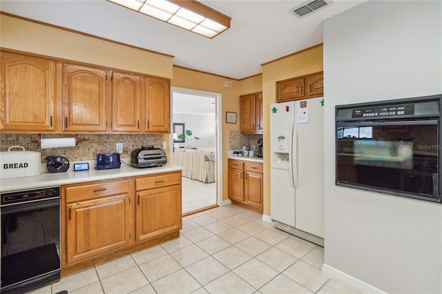 kitchen featuring black oven, light tile patterned floors, decorative backsplash, and white fridge with ice dispenser