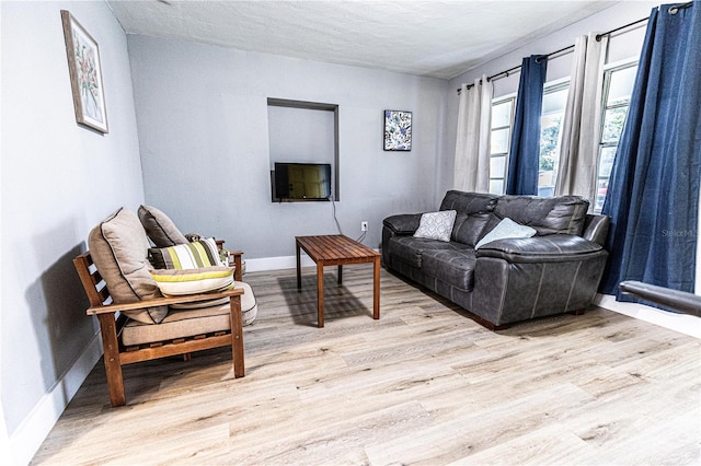 living room with light wood-type flooring and a textured ceiling