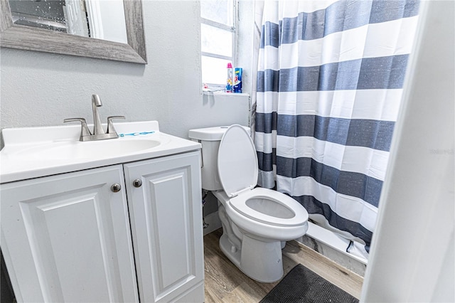 bathroom featuring a shower with shower curtain, toilet, hardwood / wood-style flooring, and vanity