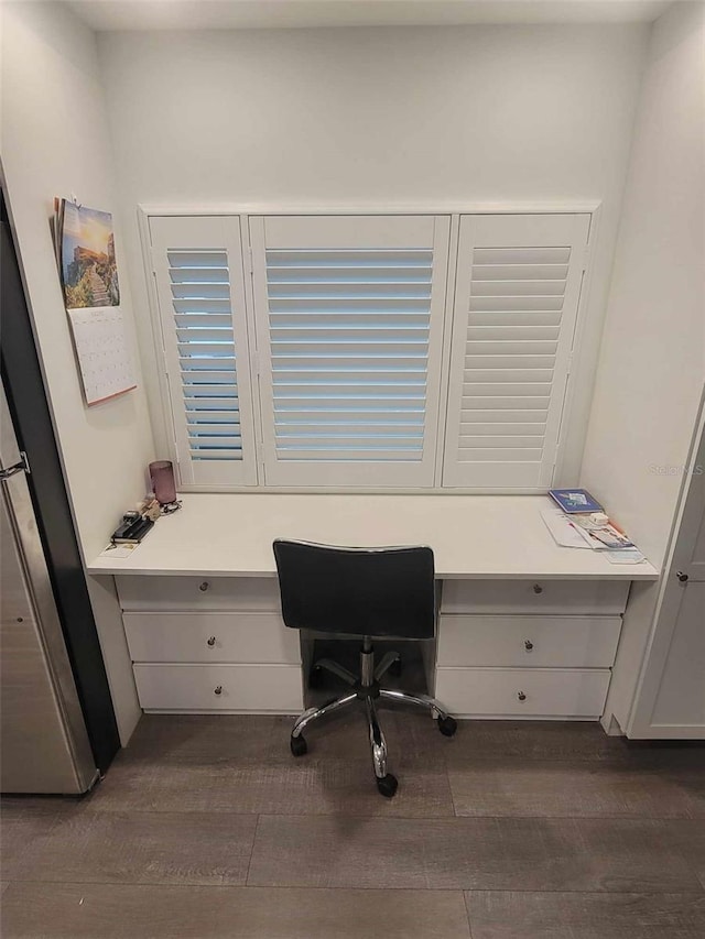 office area with dark wood-type flooring and built in desk