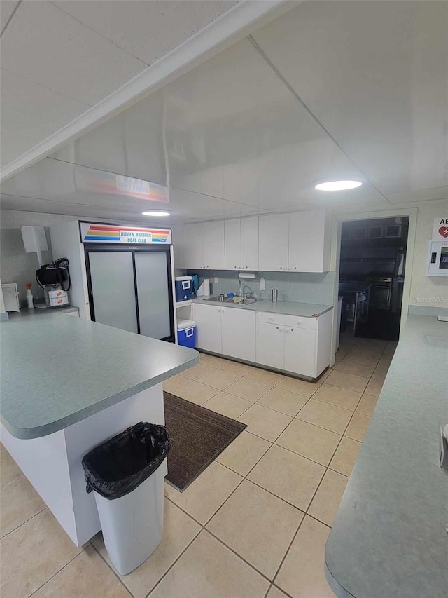 kitchen featuring light tile patterned flooring and white cabinets