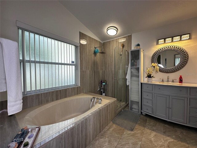 bathroom featuring vanity, lofted ceiling, and separate shower and tub