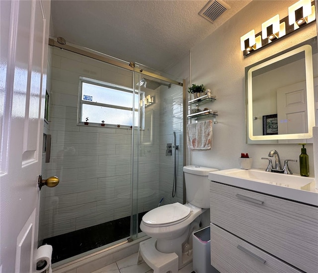 bathroom featuring toilet, a textured ceiling, walk in shower, and vanity