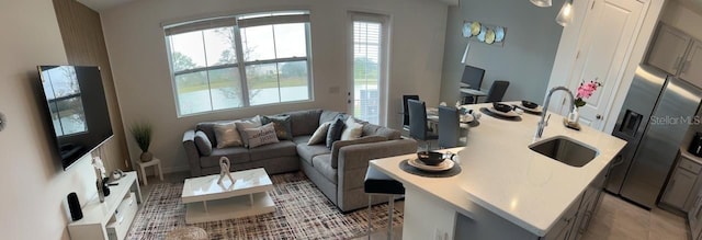 tiled living room featuring a healthy amount of sunlight and sink