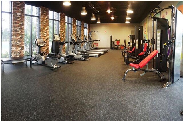 718 Longboat Dr, Davenport, FL 33896 - exercise room featuring brick wall