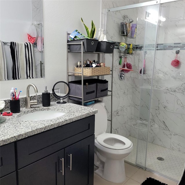 bathroom featuring vanity, toilet, an enclosed shower, and tile patterned floors