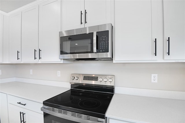 kitchen featuring stainless steel appliances and white cabinetry