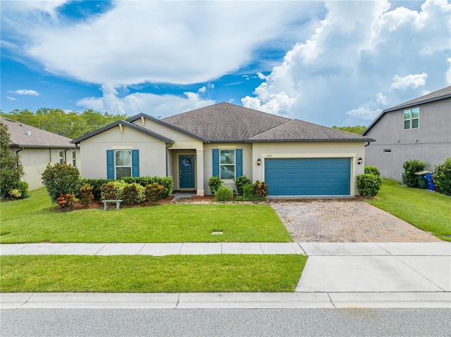 ranch-style home featuring a garage, decorative driveway, a front lawn, and stucco siding