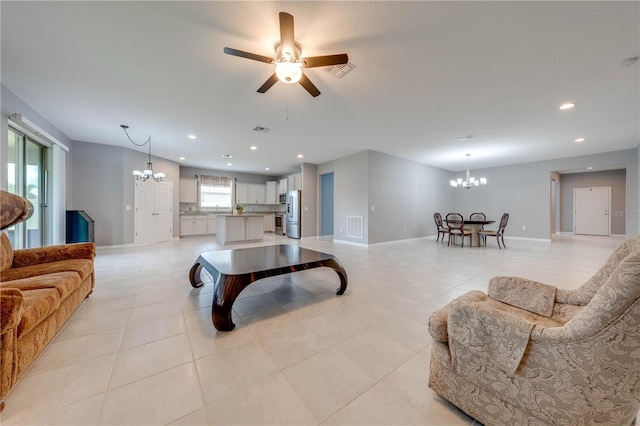 tiled living room featuring ceiling fan with notable chandelier